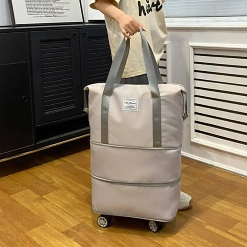 Wheeled Personal-Item Travel Bag — the bag held by its carry handle in a room, wheel base fitted