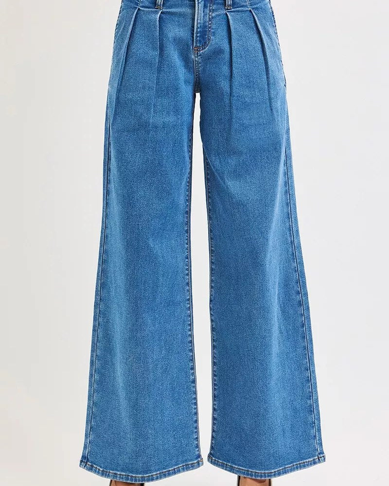 Medium-blue mid-rise pleated wide-leg jeans worn by a model
